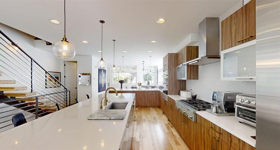 White quartz countertops and a huge island makes dining an interactive event in this space.
