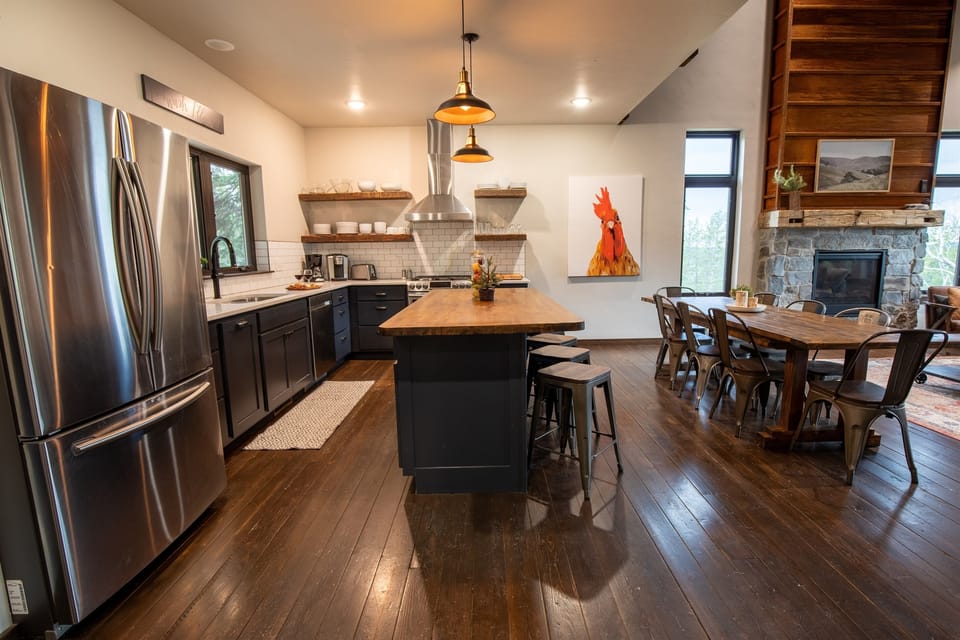 The oversized island is your command center — bar stools along the edge, butcher block surface, and the whole kitchen at arm's reach. Pre-ski breakfasts for twelve start here.