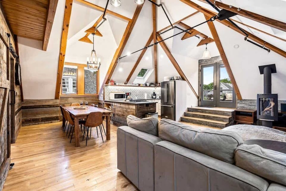 Living room area in the Loft Apartment with open concept, exposed beams, and a fireplace for the chillier nights. 