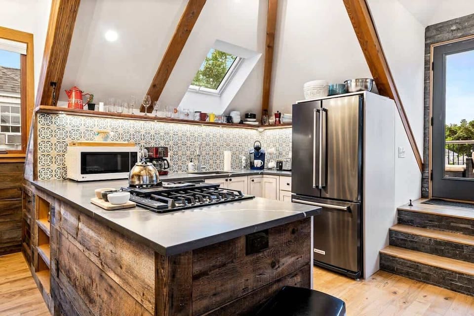 Fully equipped third-floor kitchen featuring a gas stovetop, full-size refrigerator and freezer, and everything you need to cook meals or enjoy your morning coffee.