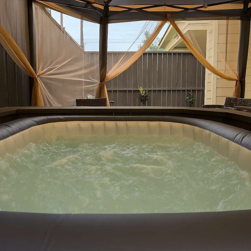 Private spa under canopy with stone deck and fence enclosure