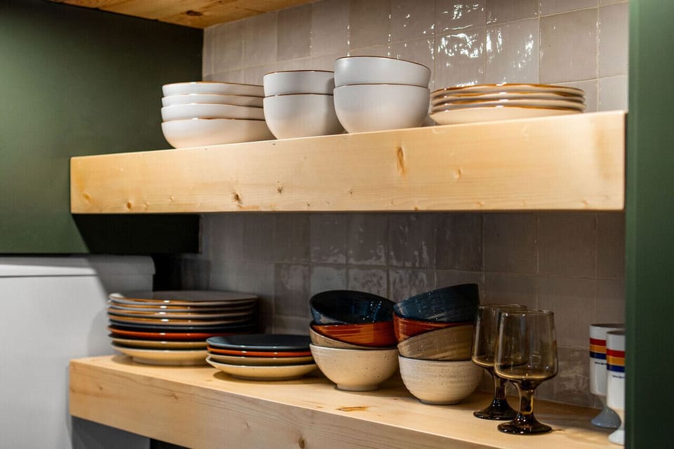 The kitchen features a two-burner electric cooktop, ice maker, microwave, toaster, blender, dishwasher, and refrigerator, along with a coffee maker that uses our custom Hideout coffee blend.