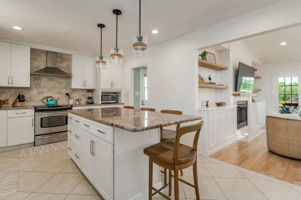 The kitchen boasts modern comforts with sleek stainless steel appliances and a spacious island, perfect for meal prep and casual dining!