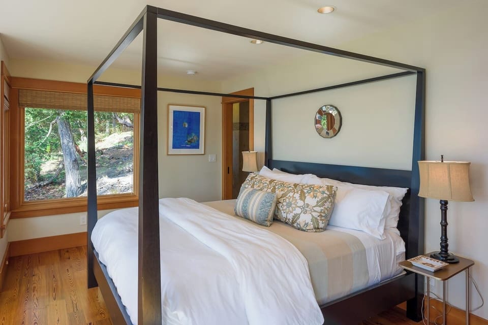 Comfortable bedroom featuring a stylish canopy bed, soft linens, and a serene setting.