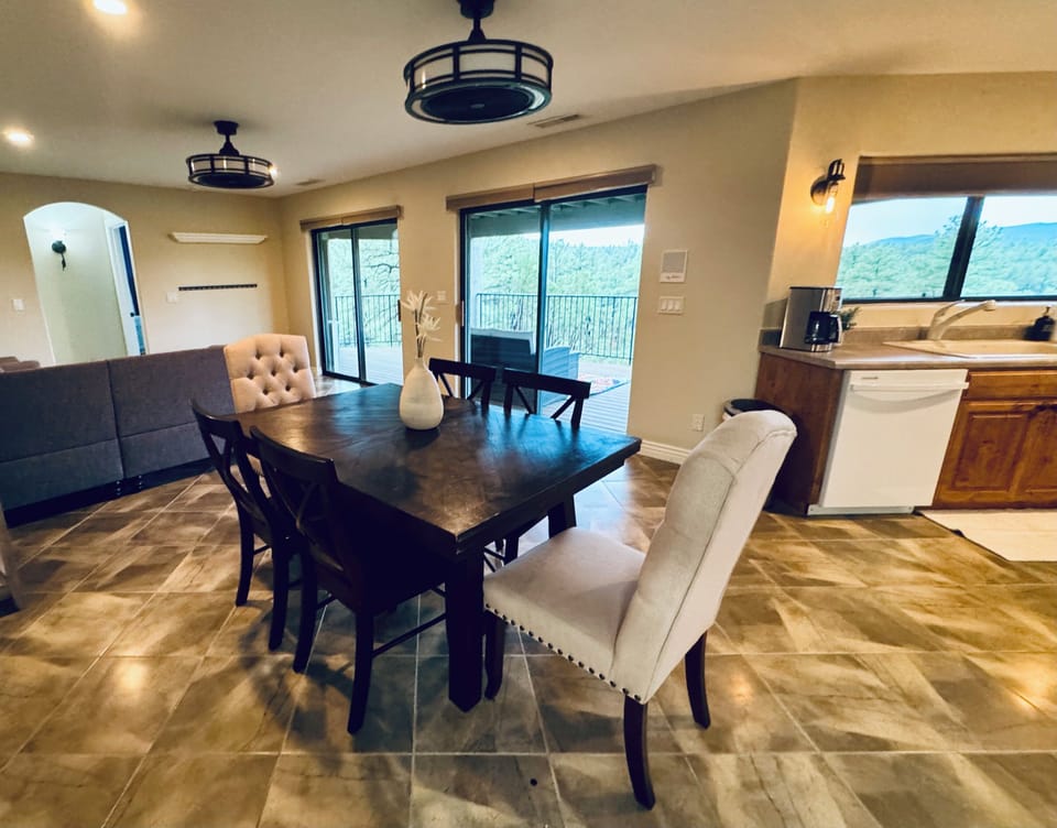 Elegant dining with mountain vistas at The Sanctuary. Spacious table for 6, chic decor, and panoramic views. Perfect for family meals or entertaining. Open layout connects to living area and balcony. Enjoy Prescott's beauty in comfort.
