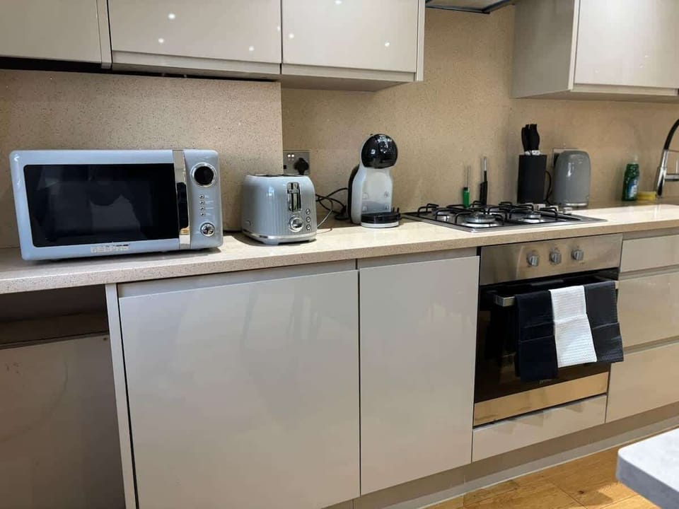- Kitchen detail with appliances microwave toaster kettle  
- Sleek cabinets provide storage and modern look  
- Convenient setup for preparing meals anytime  