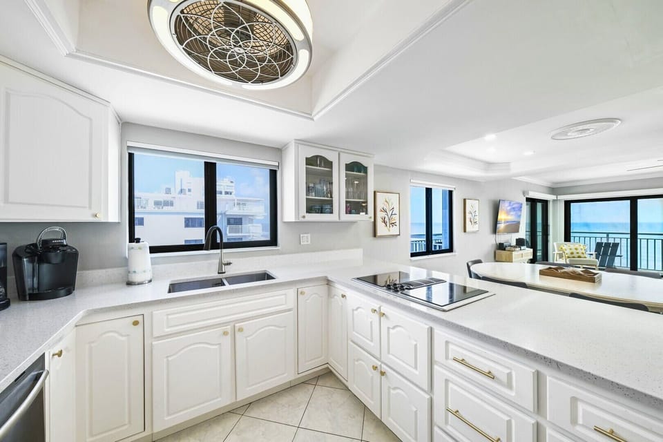 Corner-unit layout delivers panoramic ocean and pool views from the kitchen, dining area, and living room.