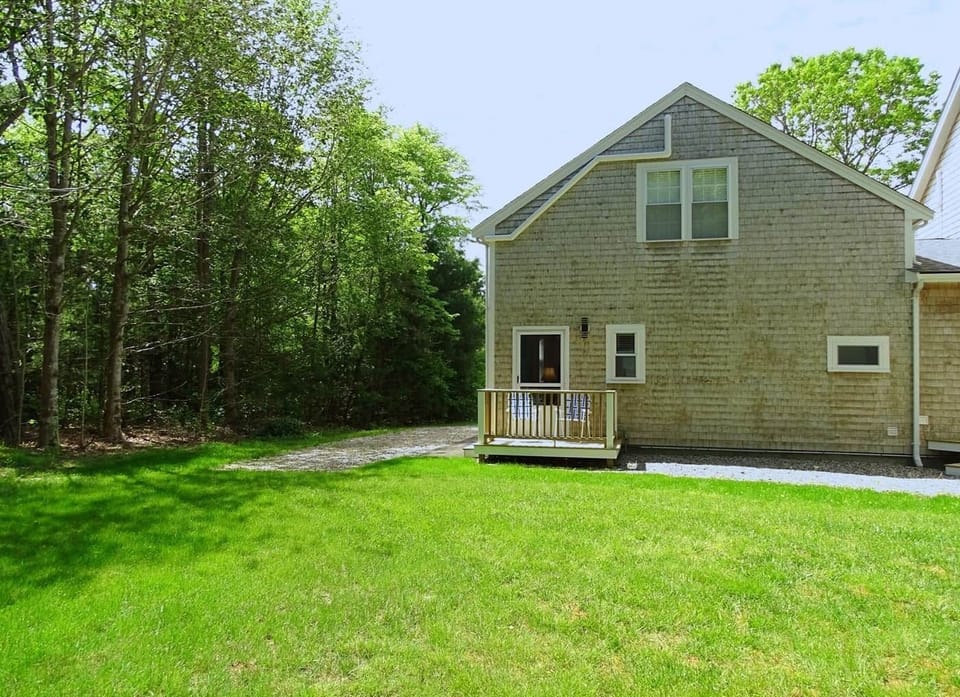 Deck off kitchen with chairs facing large yard