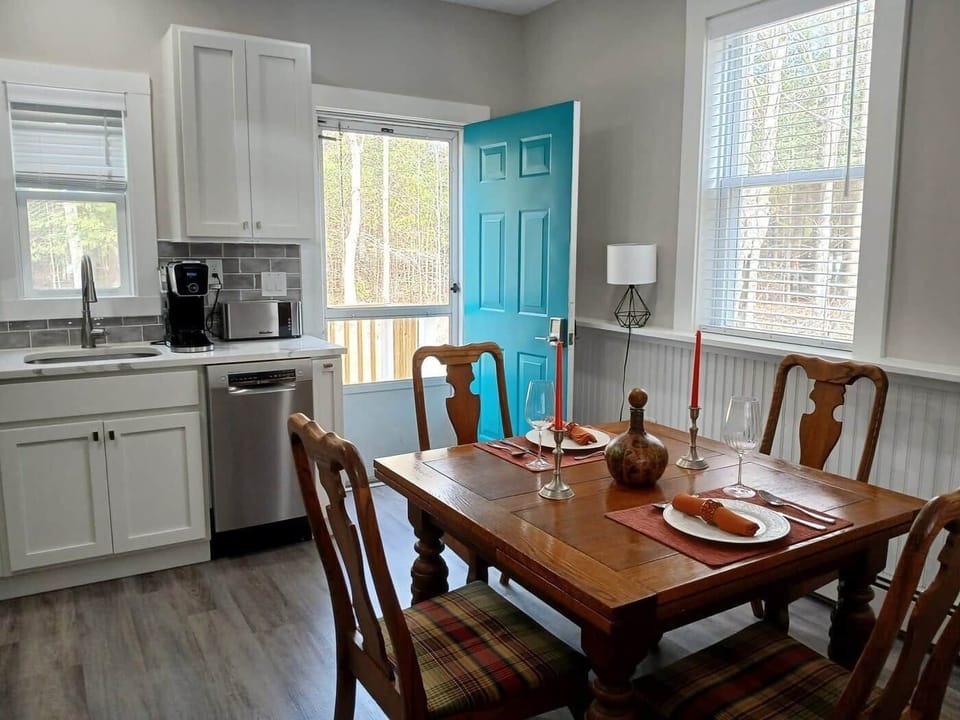 Kitchen dining area with back door leading to porch and backyard