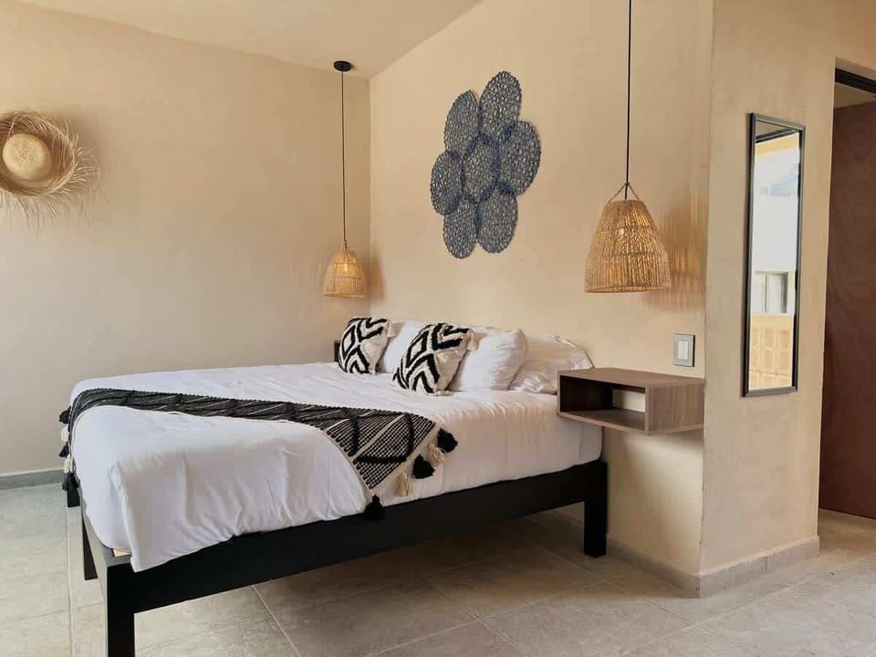 King bed with stylish decor and pendant lighting