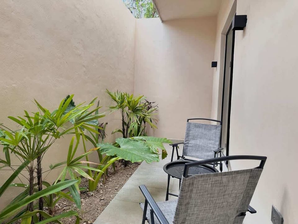 Private patio with seating and greenery