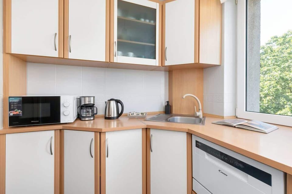 The kitchen's sleek design includes all necessary cookware and utensils. 