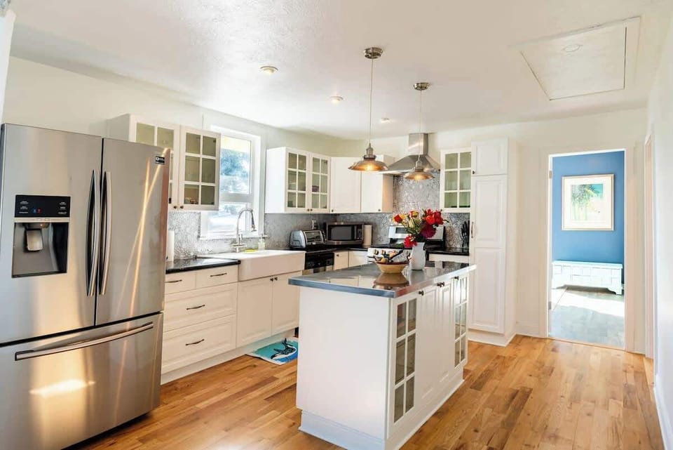 Bright modern kitchen with a central island, stainless steel appliances, and plenty of space for cooking.