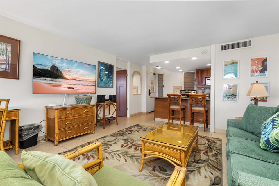 Relax in your tropical-themed living space where coastal colors and rattan furnishings create a vacation vibe, complete with an open kitchen for easy entertaining.