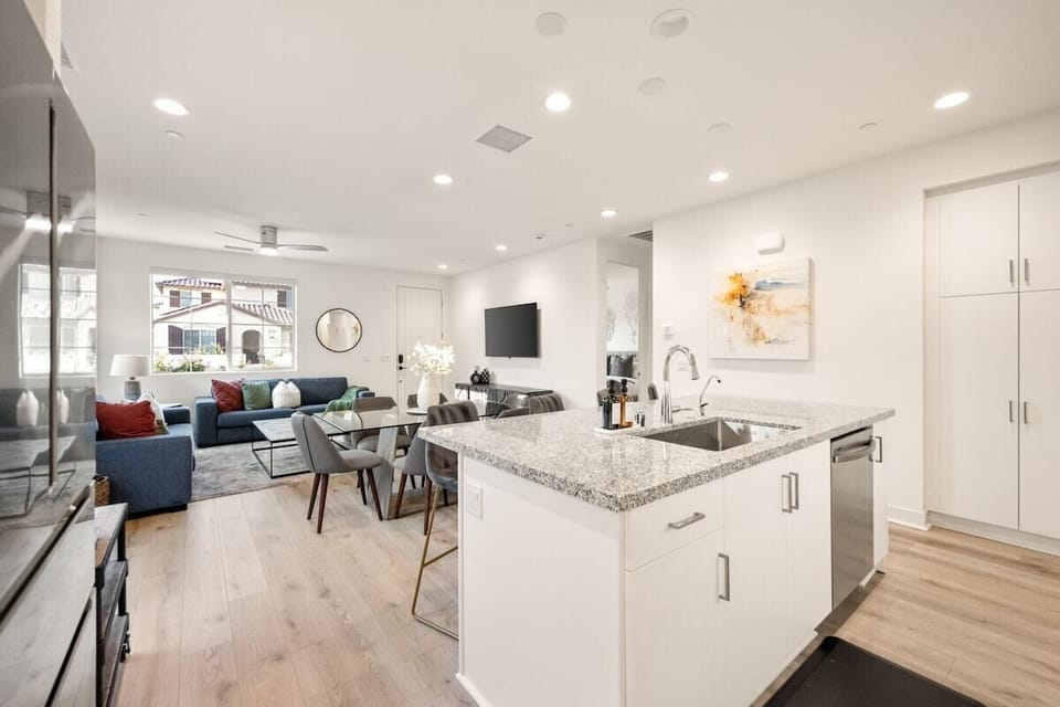 Modern kitchen with granite counters and stainless appliances opens to the dining and living areas.