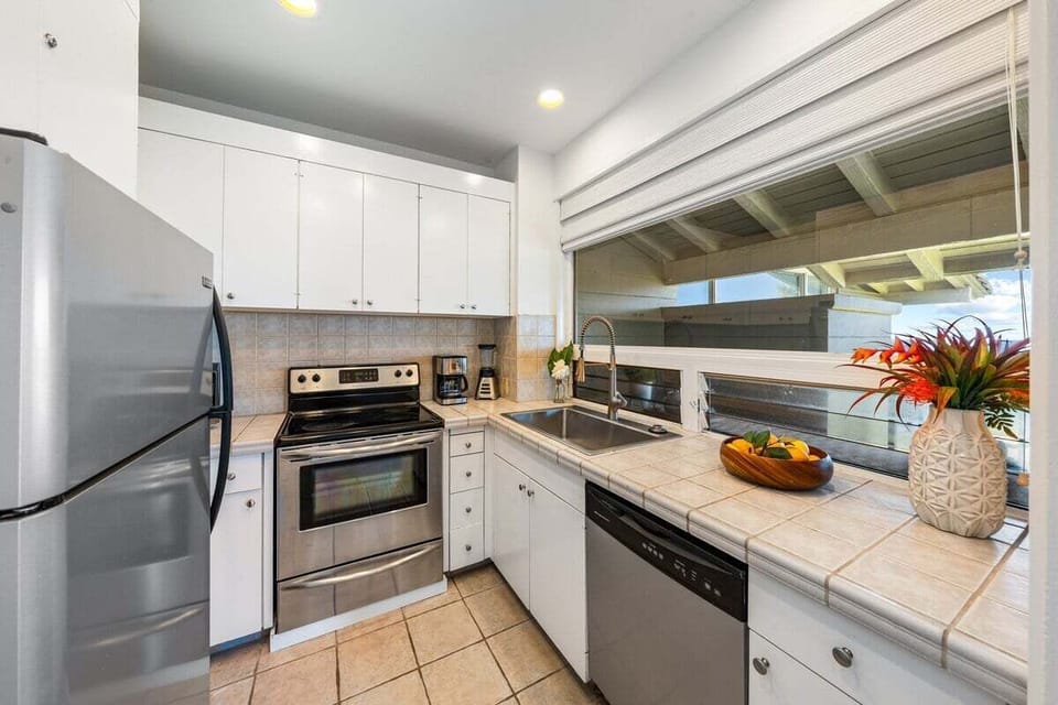 Well-appointed kitchen with full-size appliances, white cabinetry, generous counter space, and a seamless layout ideal for preparing meals during extended island stays.