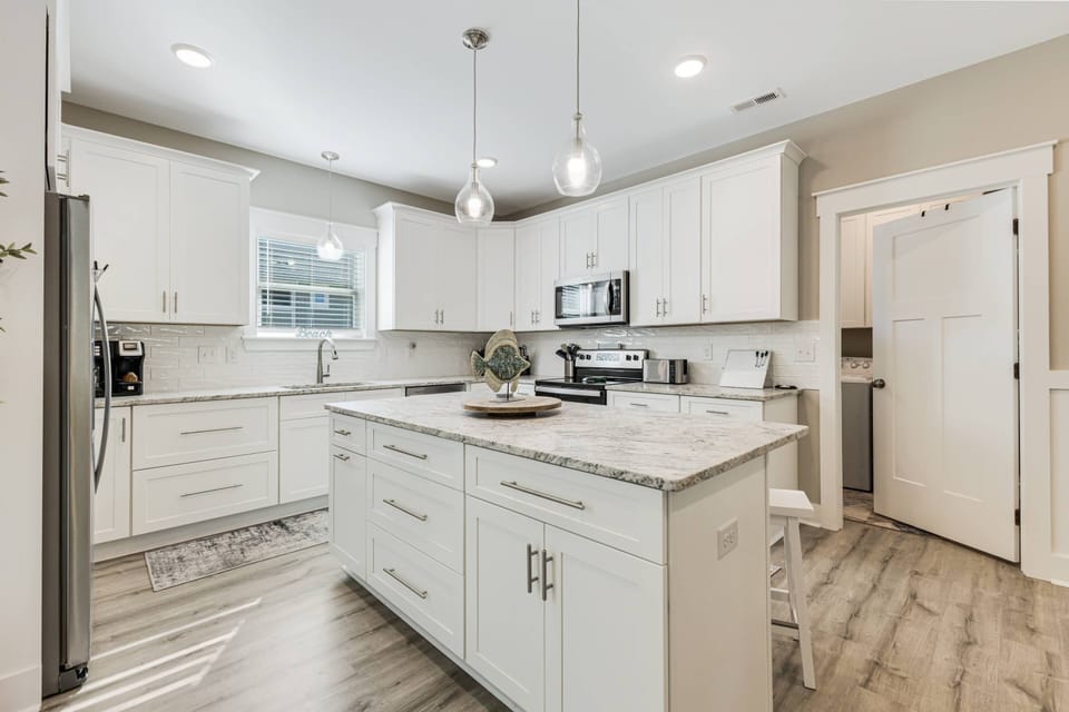 Bright and inviting kitchen featuring modern appliances. The side door conveniently leads to the laundry area and backyard pool.