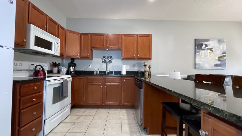 Enjoy culinary adventures in our tidy, cozy kitchen, featuring a long table and chairs for shared meals!
