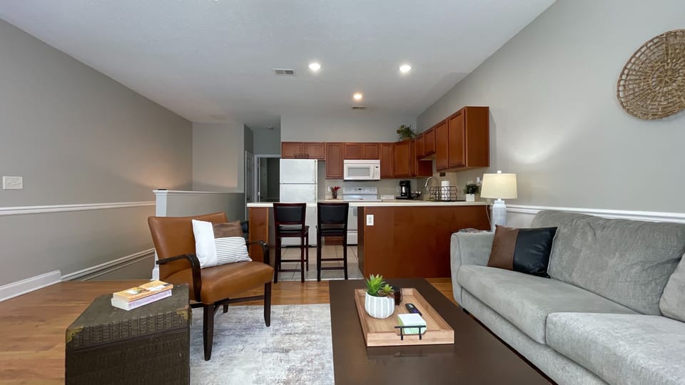 eel at ease in our cozy living room, featuring a plush couch and a view of the sleek kitchen—perfect for your getaway!