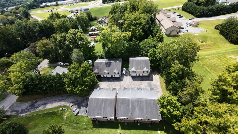 Aerial view of a serene property, surrounded by lush greenery for a refreshing escape.