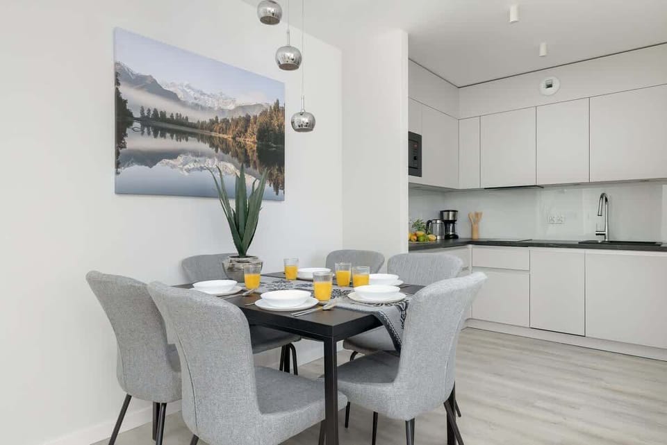 A bright kitchen with clean white cabinets and a minimalist design. Ideal for cooking and entertaining guests.