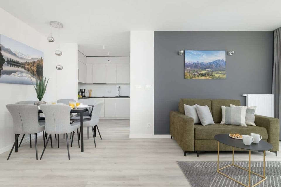 A modern kitchen with white cabinetry and a sleek black cooktop. Fresh lemons on the counter add a pop of color.