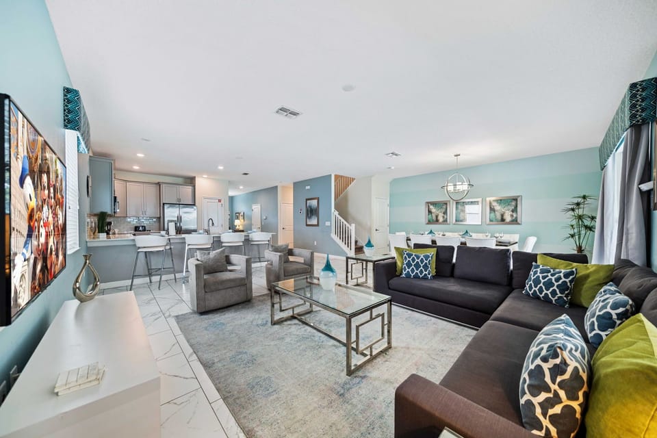 - Spacious open-plan living area with stylish modern decor and plenty of seating - Features a large sectional sofa ideal for family gatherings and movie nights - Equipped with a mounted flat-screen TV for your entertainment needs