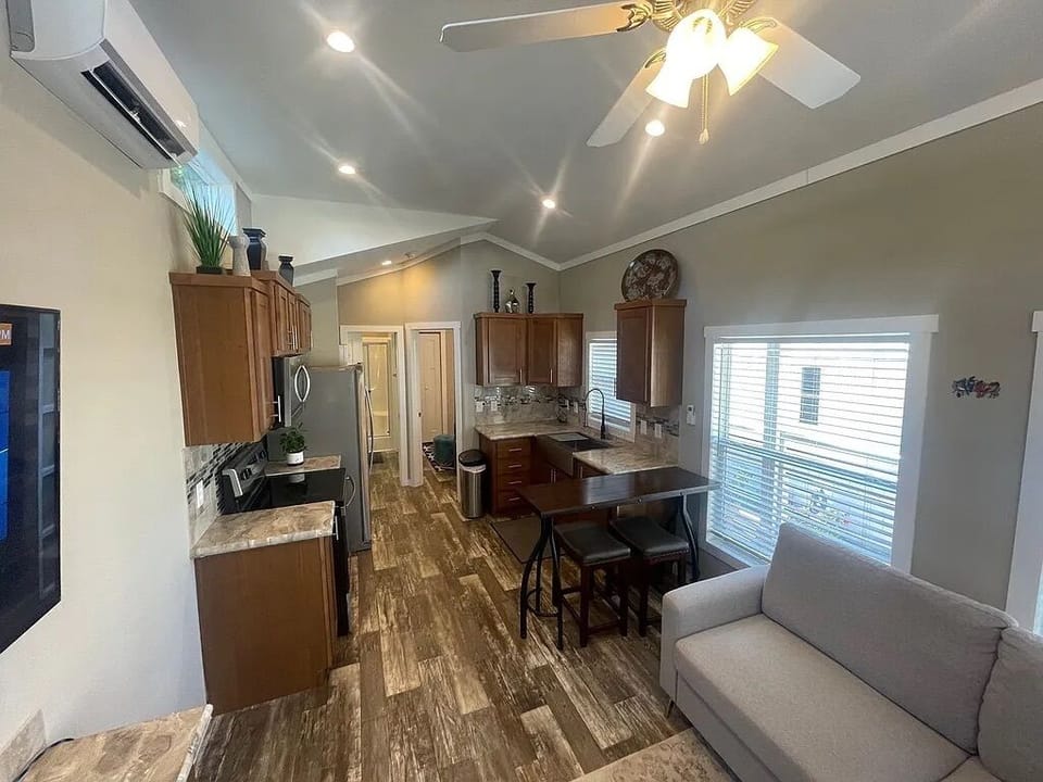 climate control, couch, stovetop, interior, refrigerator, living area, indoor, television, microwave, dining table, kitchen visible