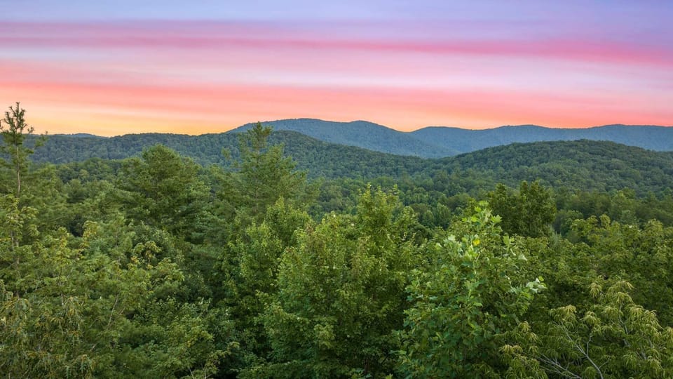 Marvel at stunning mountain and tree views as the sun sets, right from the comfort of our cozy cabin!