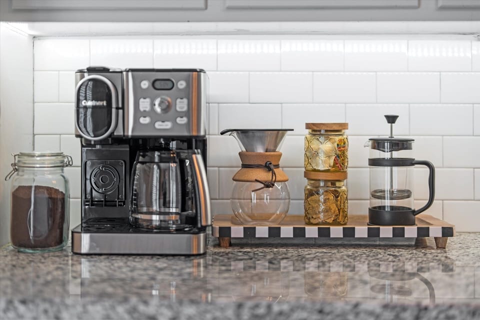 Thoughtfully stocked coffee station with drip, K-Cup, French press, pour over, coffee grounds, sugar and creamer to start your mornings right.