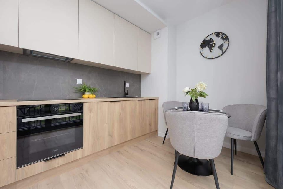 A compact and modern kitchen area with wooden cabinets and a black countertop. Fully equipped and perfect for preparing home-cooked meals.