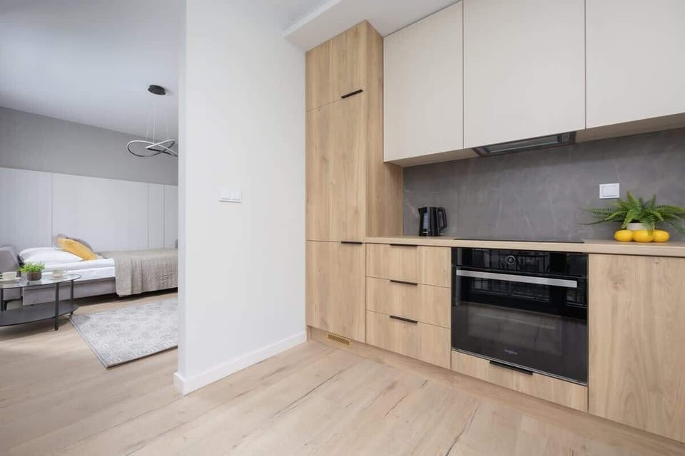 A view of the kitchen and hallway area with natural wood finishes and clean white walls. The functional layout makes the most of the available space.