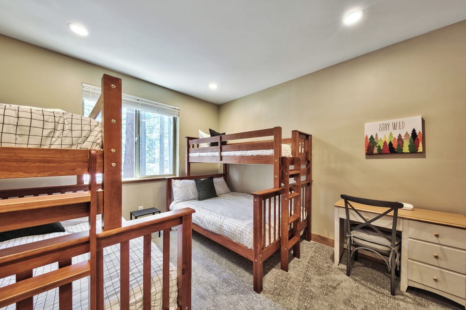 Your kids will love this cozy bunk room with sturdy wooden beds and cheerful mountain decor.