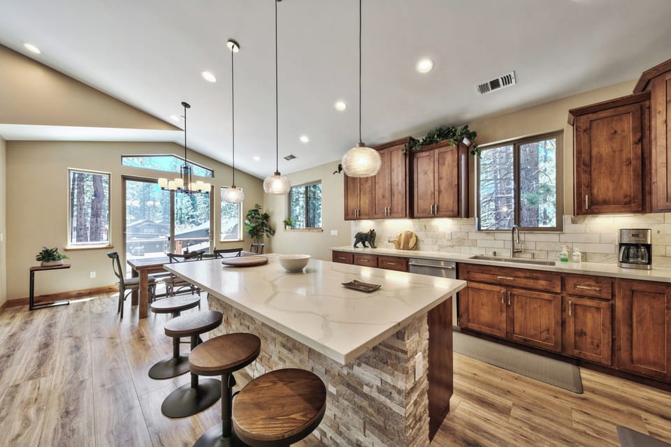 Your gourmet kitchen features rich wood cabinets, quartz counters, and a spacious island where you'll love preparing meals while enjoying forest views.