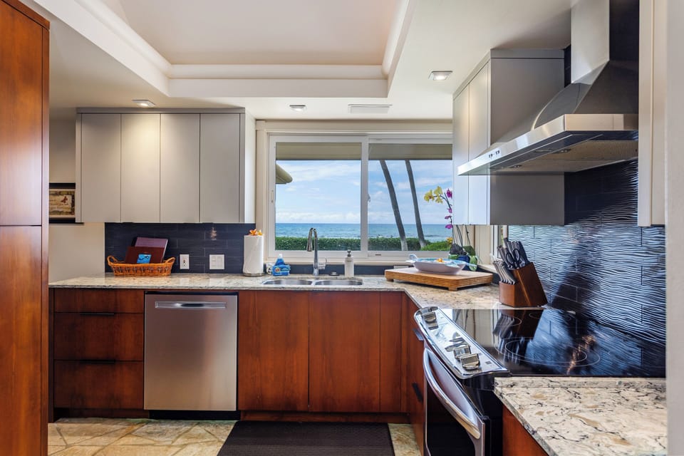 Kitchen - Cook your favorite meals in this fully equipped gourmet kitchen with sleek modern appliances, granite countertops, and stunning ocean views through large windows that bring the outdoors in.
