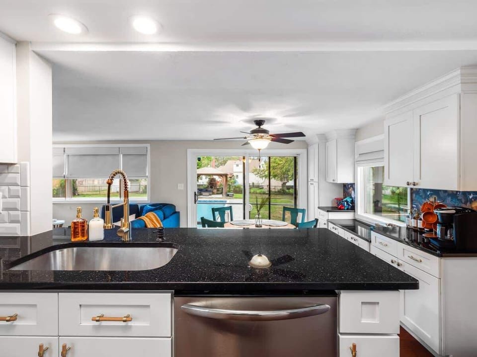Open kitchen w/ large island, bar stools & seamless flow to living area