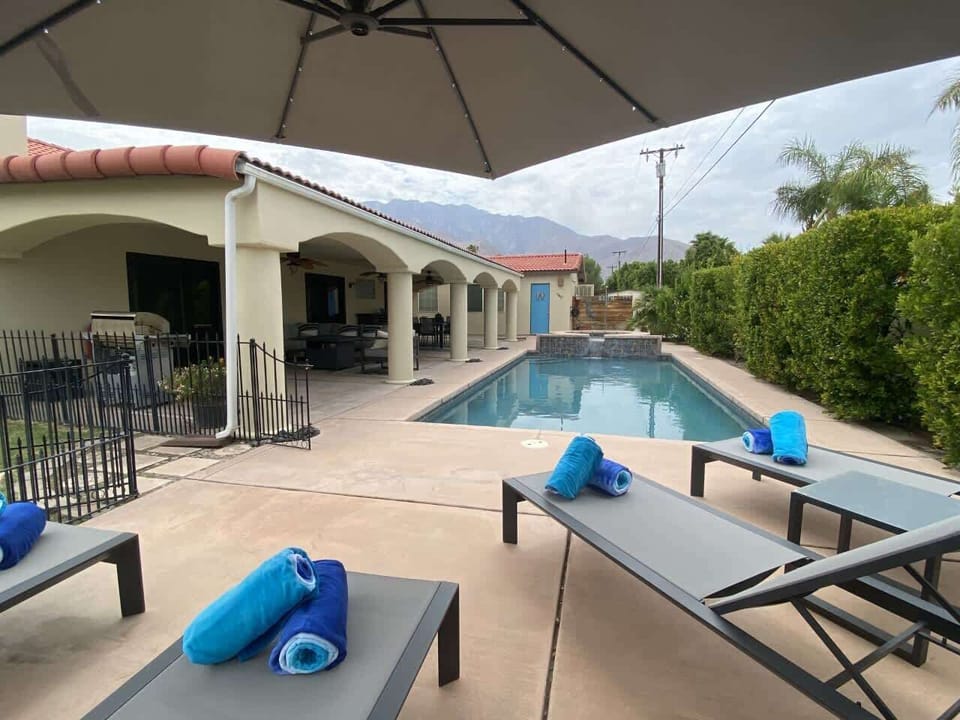 Outdoor lounge with fire pit, BBQ, and fans