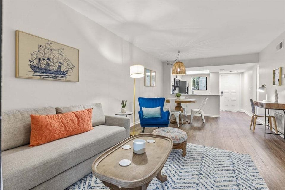 The living room offers a cozy seating area, a smart TV, and access to a private screened porch with tranquil outdoor views.