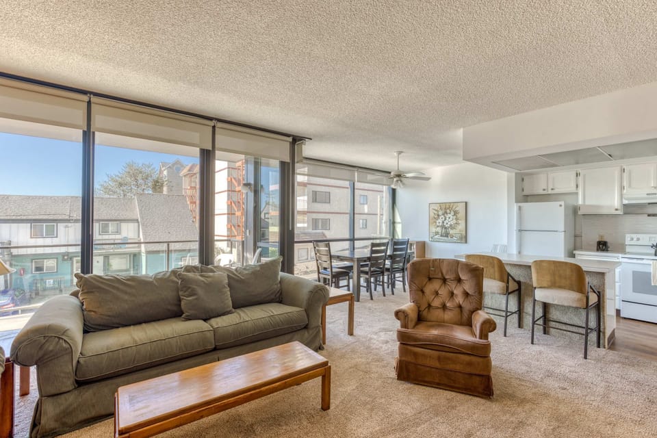 A modern, open-concept living space with large windows, cozy seating, a spacious dining area, and a bright, inviting atmosphere.