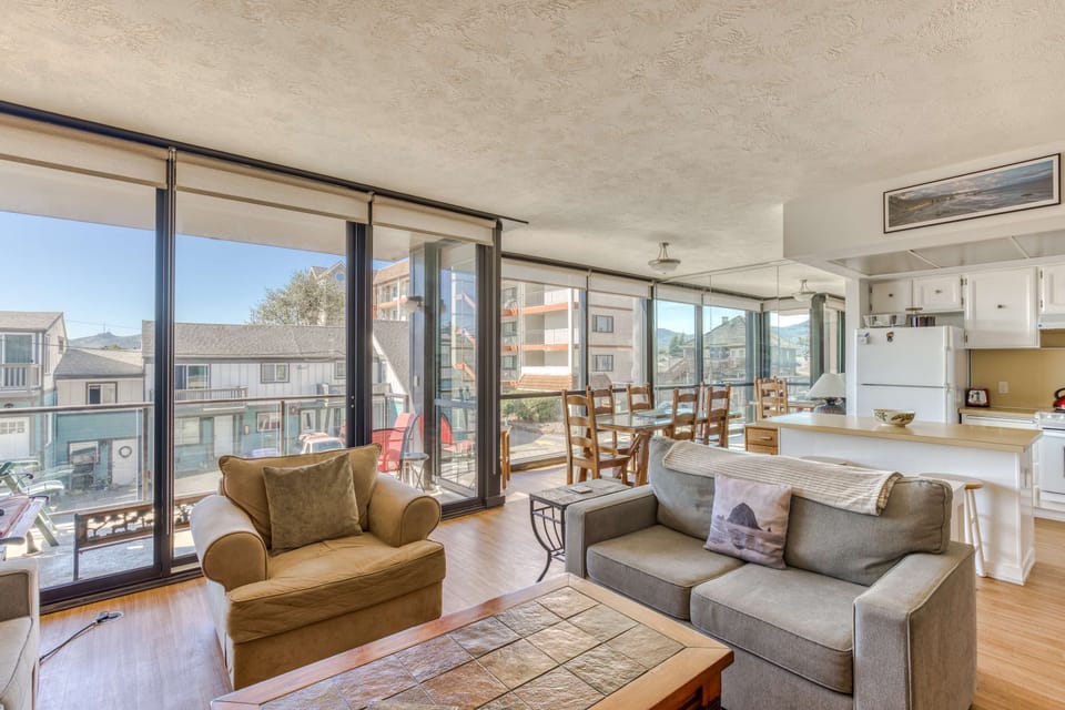 A modern, open-concept living space with large windows, cozy seating, a spacious dining area, and a bright, inviting atmosphere.