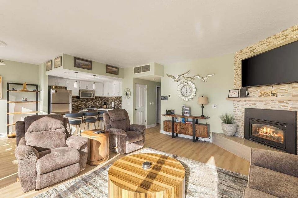 Gather, unwind, and relax in a sun-filled living space with fireplace and open kitchen.