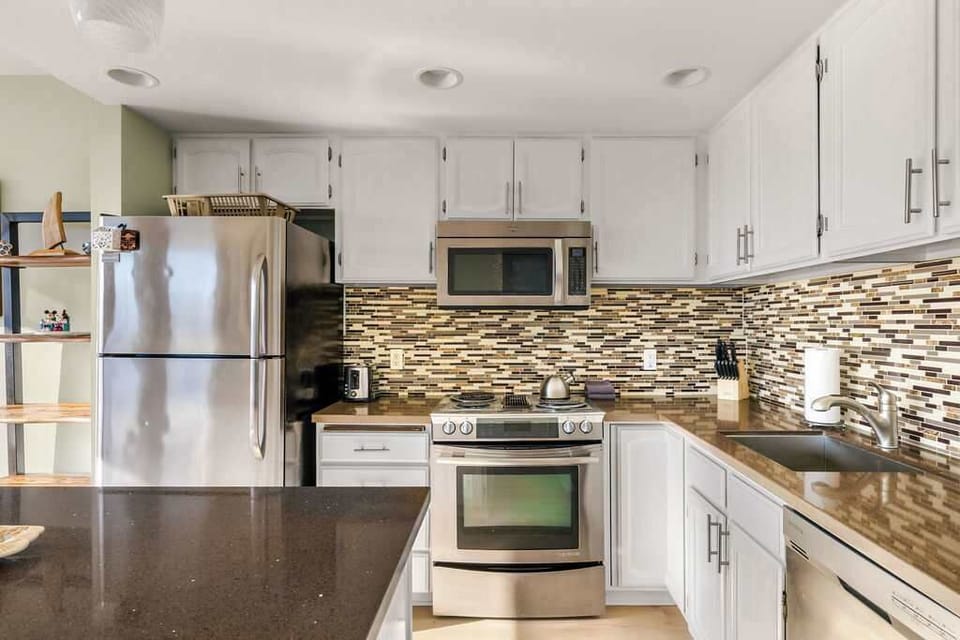 Fully equipped modern kitchen with stainless steel appliances, sleek cabinetry, and ample counter space.