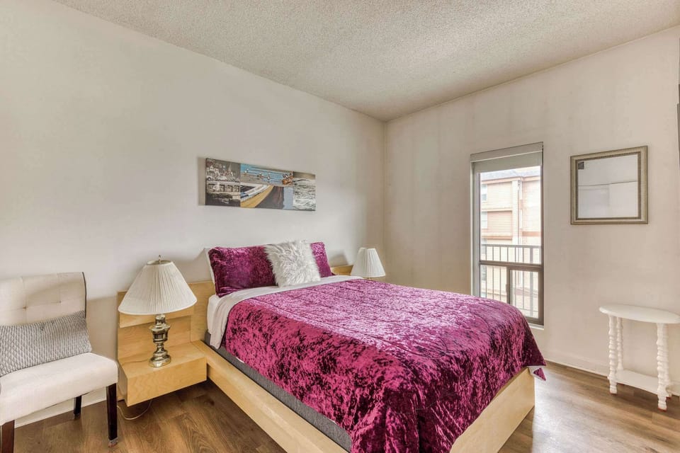 Spacious guest room furnished with a queen bed, nightstand, and closet.