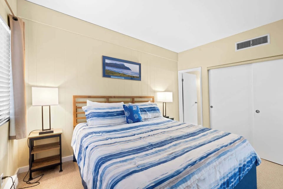 Find your calm! This charming bedroom with a plush bed and seaside art is perfect for unwinding.