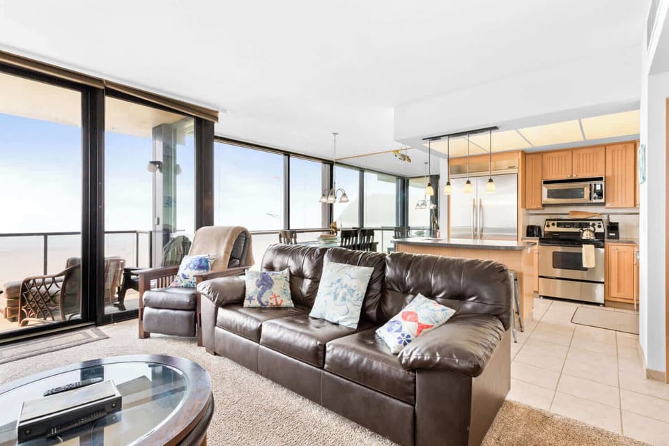 This open-concept space features a comfortable living area, a fully equipped kitchen, and panoramic views from expansive windows.