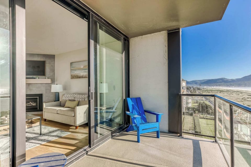 Your private balcony with a view! Step outside from the comfortable living room to enjoy breathtaking ocean and mountain scenery, perfect for relaxation.