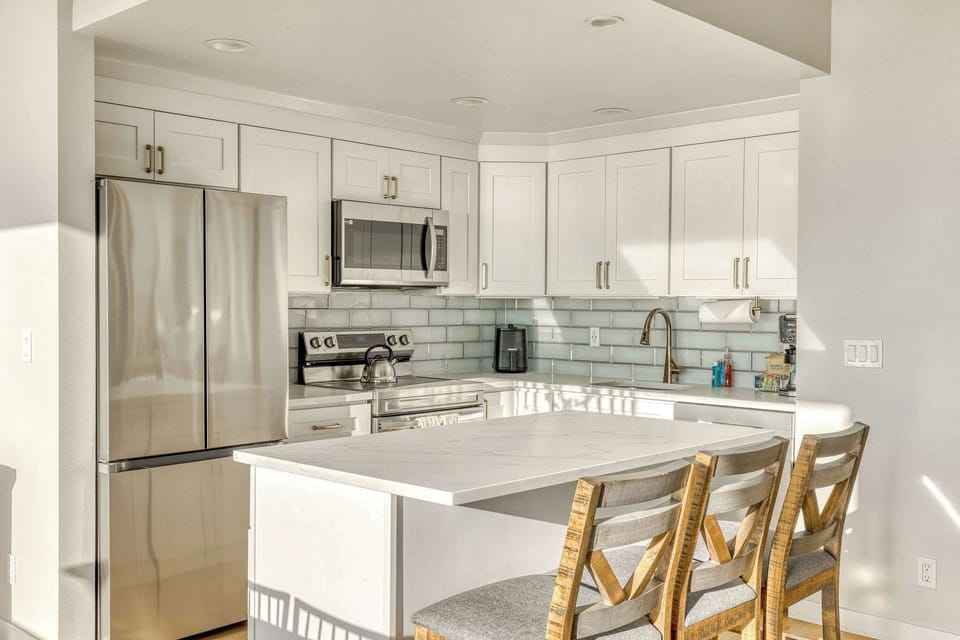 Whip up delicious meals in this bright and modern kitchen. Boasts clean white countertops, ample storage, and all the essentials for your stay.