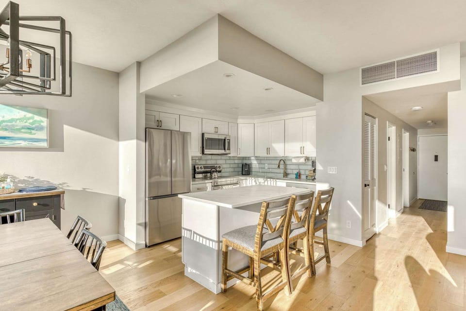 Your modern culinary hub! This fully equipped kitchen features sleek stainless steel appliances, a convenient island with seating, and ample counter space for all your needs.