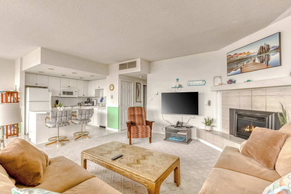 Enjoy seamless flow between the comfortable living area, complete with a cozy fireplace, and a fully equipped kitchen.