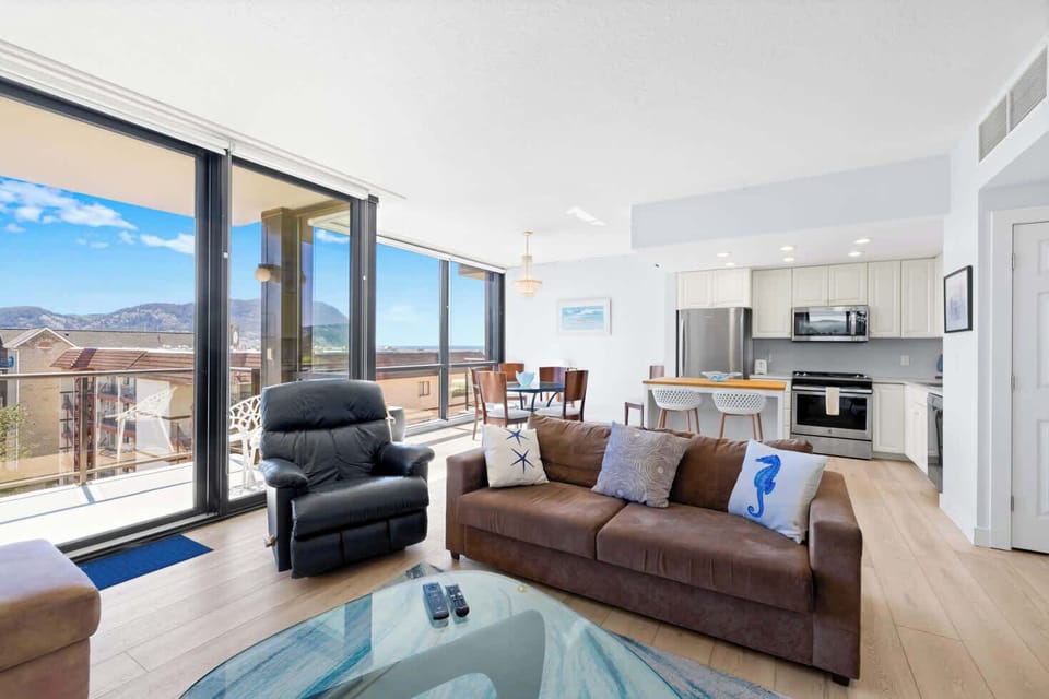 A modern, open-concept living space with large windows, cozy seating, a spacious dining area, and a bright, inviting atmosphere.